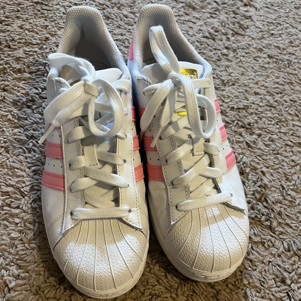 Pink and white Adidas superstars